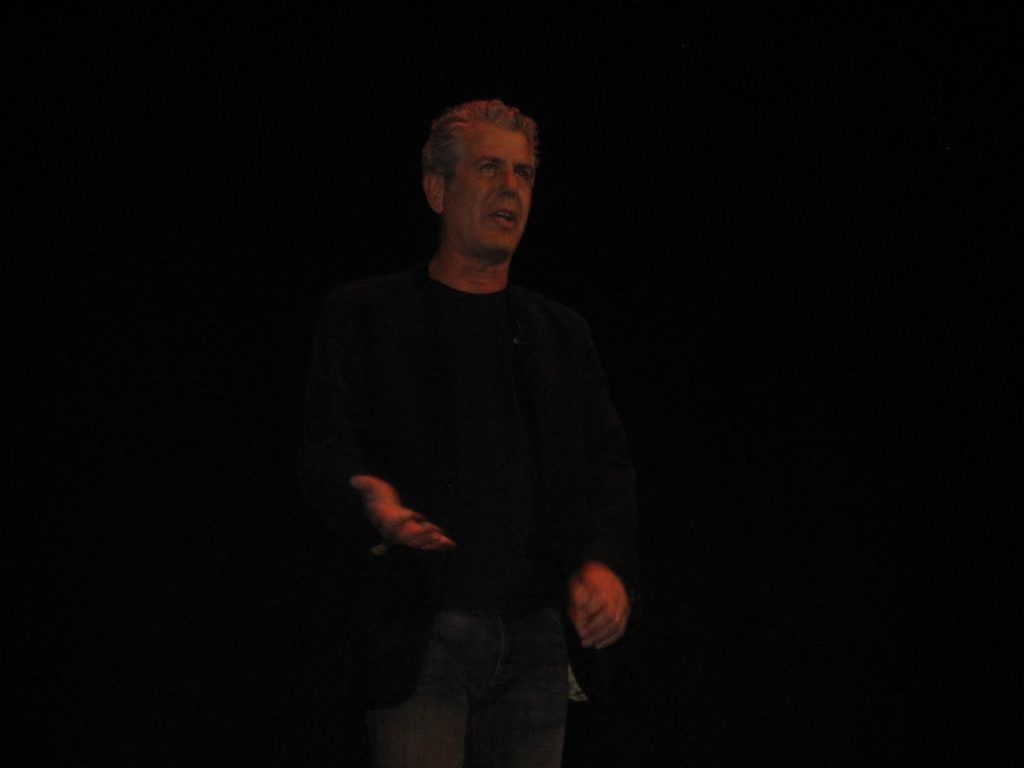 Anthony Bourdain standing in a dark room