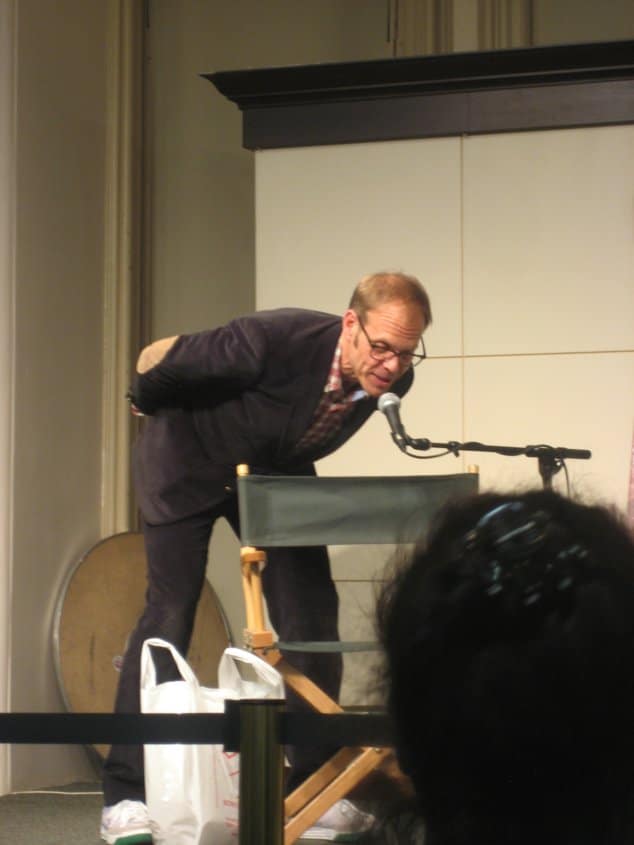 Alton Brown leaning down to speak into a microphone