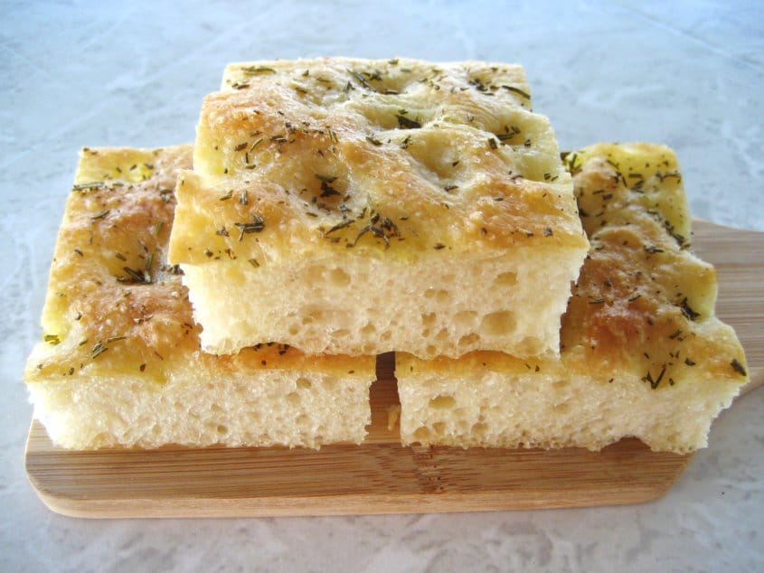 three squares of focaccia bread on a small wooden board