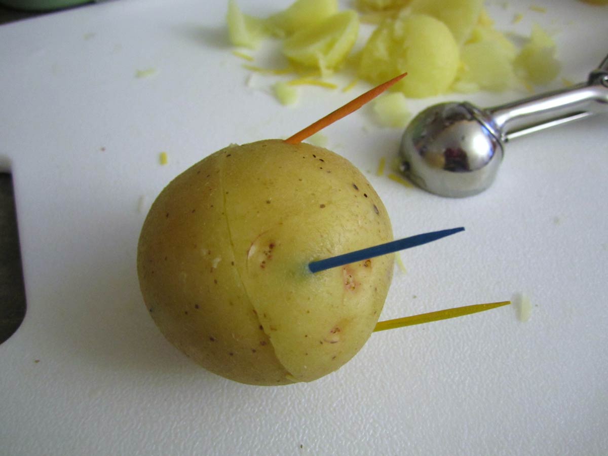 Two halves of a potato put back together using 3 toothpicks.