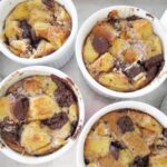 overhead view of individual s'mores bread puddings in white ramekins on a metal baking sheet