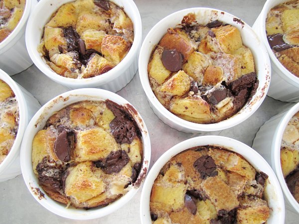 overhead view of individual s\'mores bread puddings in white ramekins on a metal baking sheet