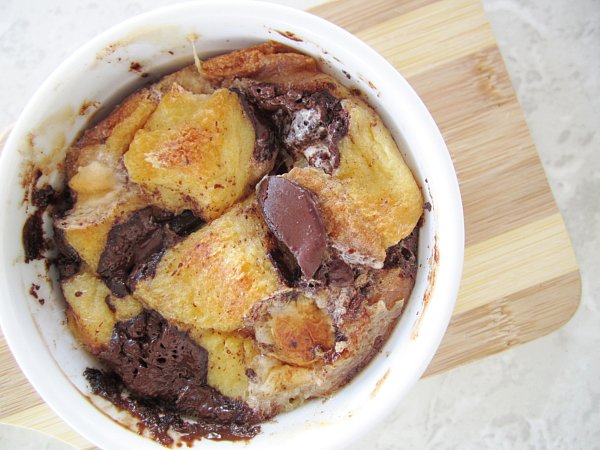 overhead closeup of s\'mores bread pudding with big chocolate chunks in a white ramekin