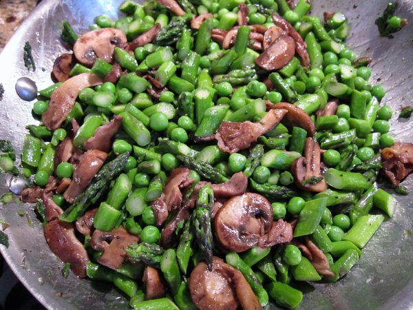 a pan of cooked chopped asparagus, mushrooms, and green peas