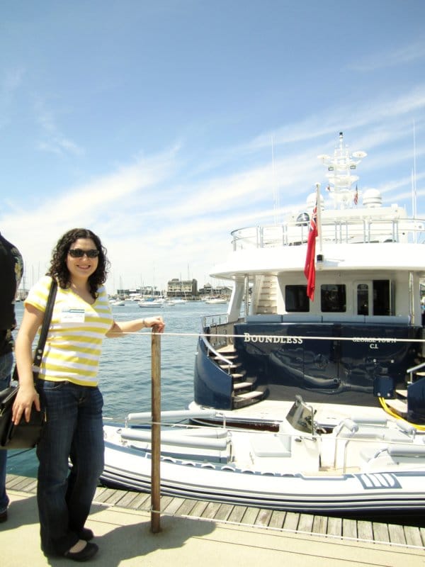 A woman posing by a boat at a dock