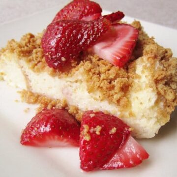 a wedge of crumb topped bread pudding with sliced strawberries over the top and sides