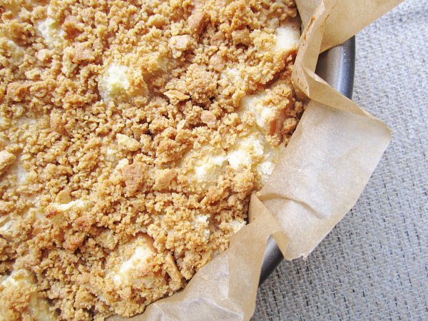 overhead closeup of a round pan lined with parchment paper and filled with crumb topped cake