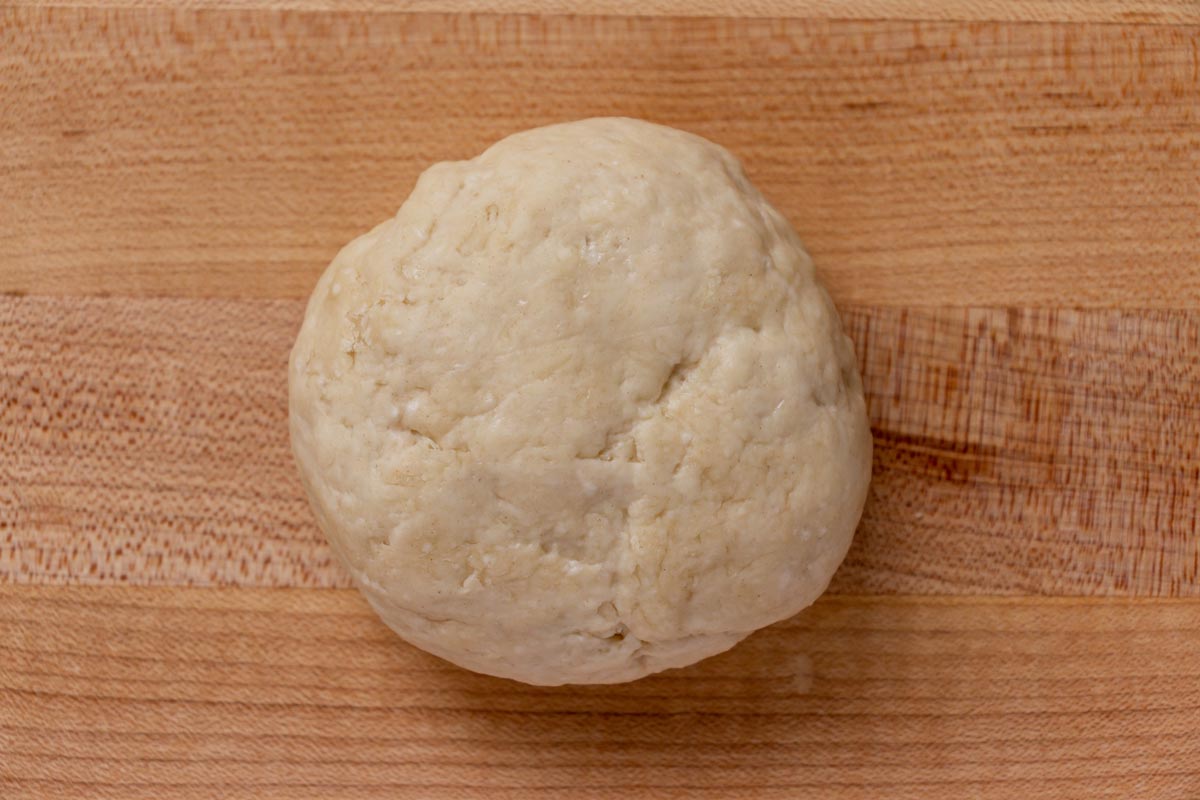 A ball of dough on a wooden board.
