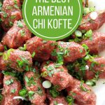 Armenian steak tartare (chi kofte) arranged on a platter and topped with chopped parsley and scallions