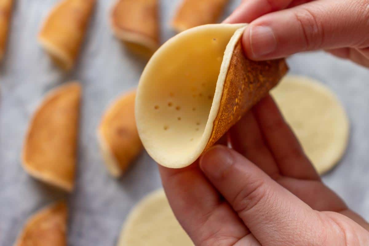 Pinching an atayef pancake into a cone shape.