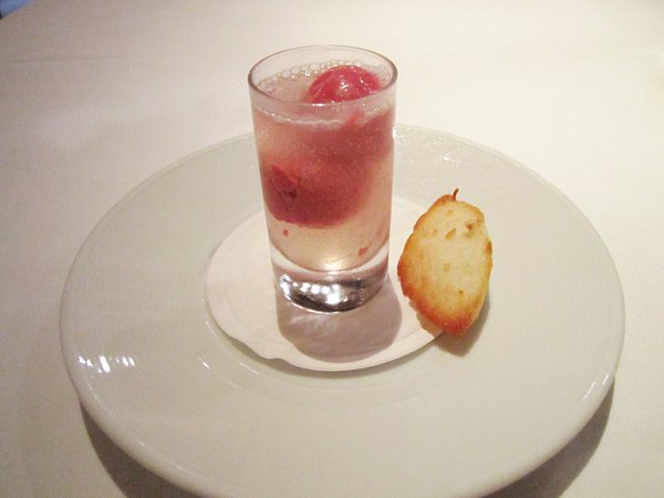 a small shot glass filled with liquid and small scoops of raspberry sorbet