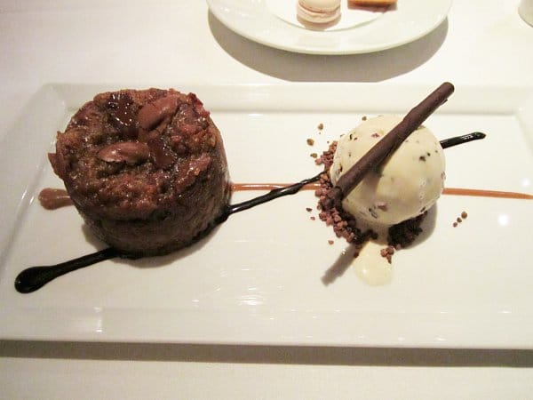 a round chocolate bread pudding with a scoop of ice cream next to it