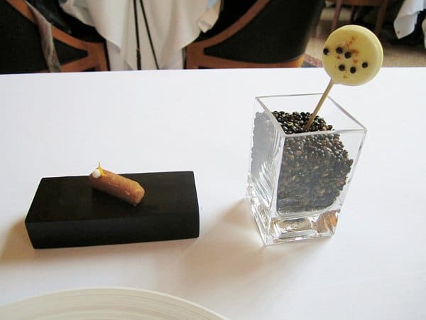 a small brown rectangle of food next to a lollipop sticking out of a glass vase