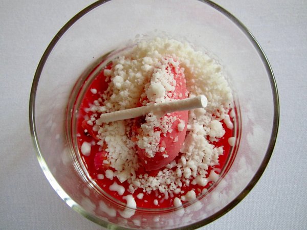 overhead view of a red berry dessert in a glass container topped with white crumbles