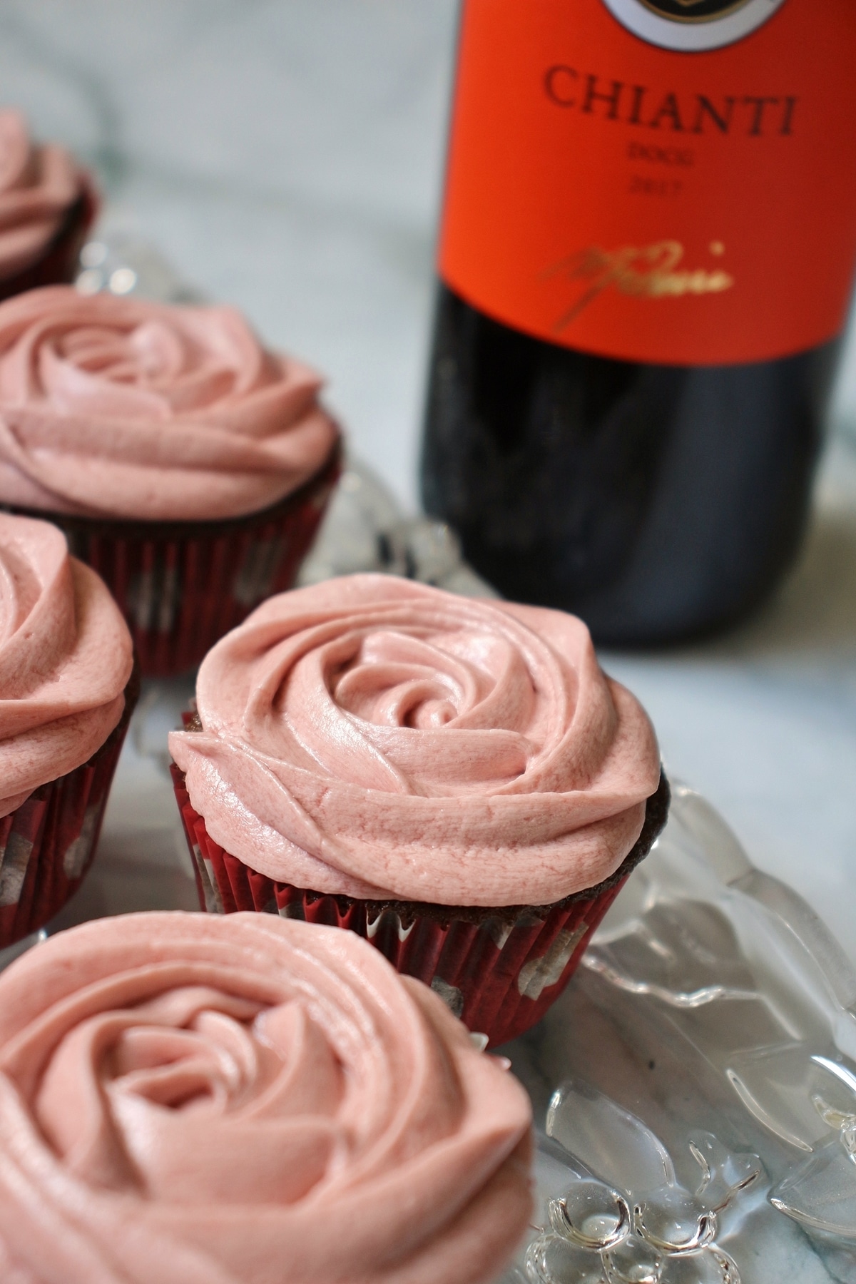 chocolate cupcakes with red wine buttercream, and a bottle of wine in the background