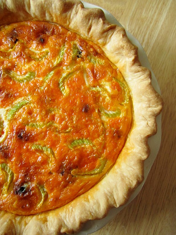 A baked buffalo chicken quiche with sliced celery on top.