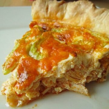 closeup of a slice of buffalo chicken quiche on a white plate