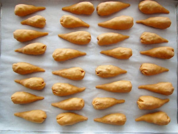 overhead view of orange cone shaped dumplings arranged on a white surface