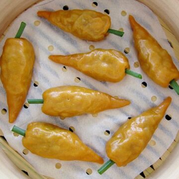 overhead view of carrot shaped dumplings in a bamboo steamer basket