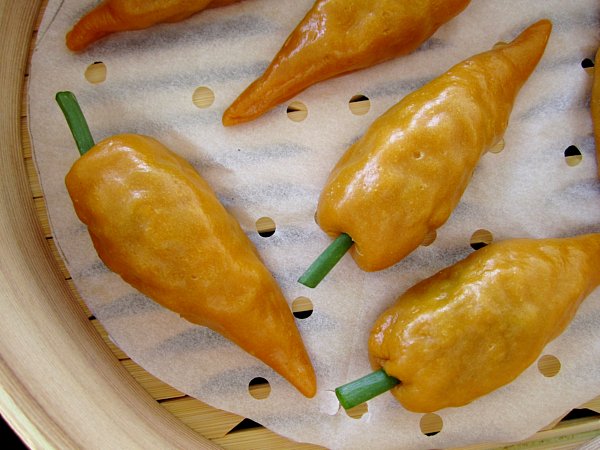 overhead closeup of carrot shaped dumplings in a bamboo steamer basket