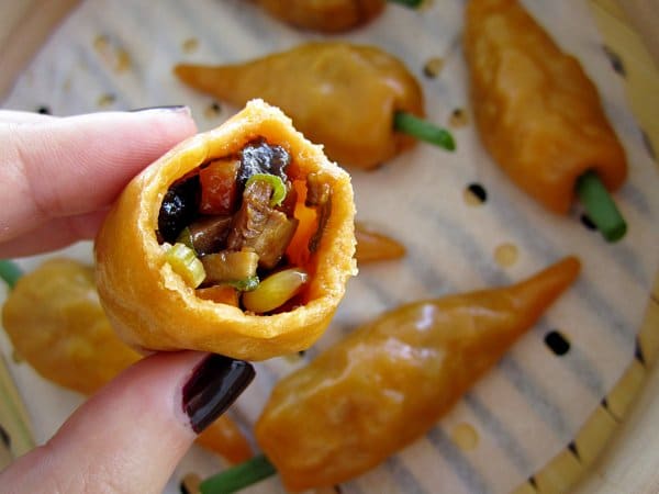 closeup of a half-eaten carrot dumpling with mushroom, carrot, and corn filling