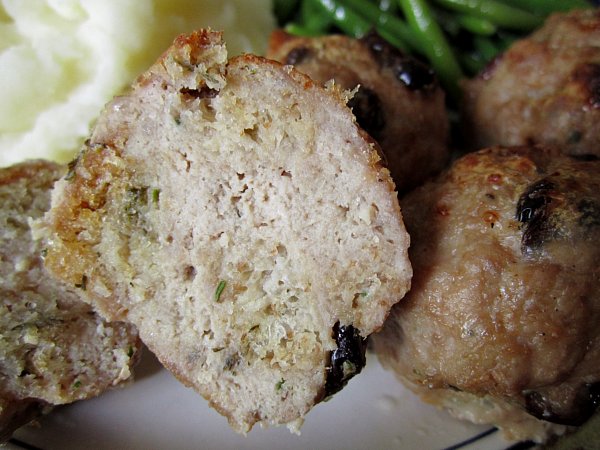 A closeup of a halved meatball on a plate