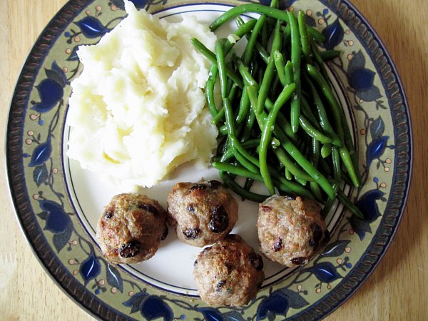 overhead view of a plate of meatballs with mashed potatoes and green beans