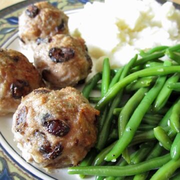 a closeup of meatballs and green beans on a plate