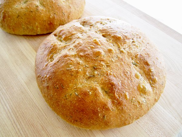 two round loaves of bread on a wooden board