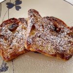 overhead view of two slices of French toast topped with powdered sugar