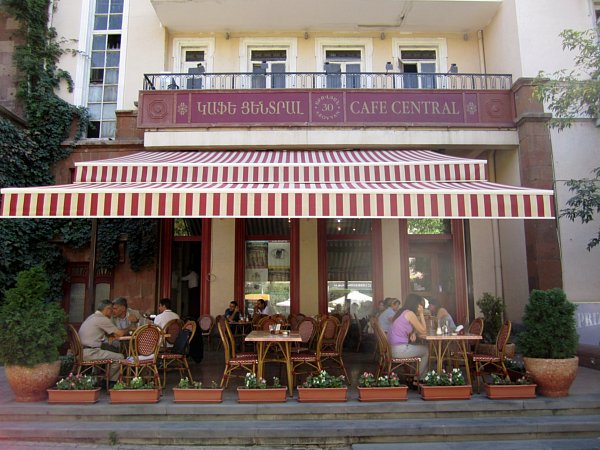 exterior of a cafe with striped awning and a sign that says Cafe Central