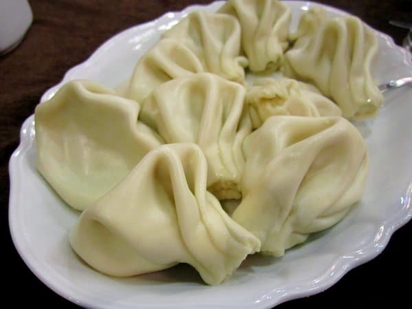 a white platter of large khinkali dumplings