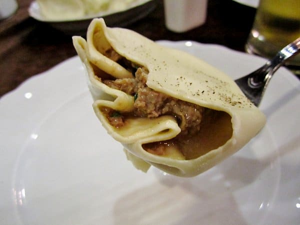 a half eaten khinkali dumpling filled with meat and juices