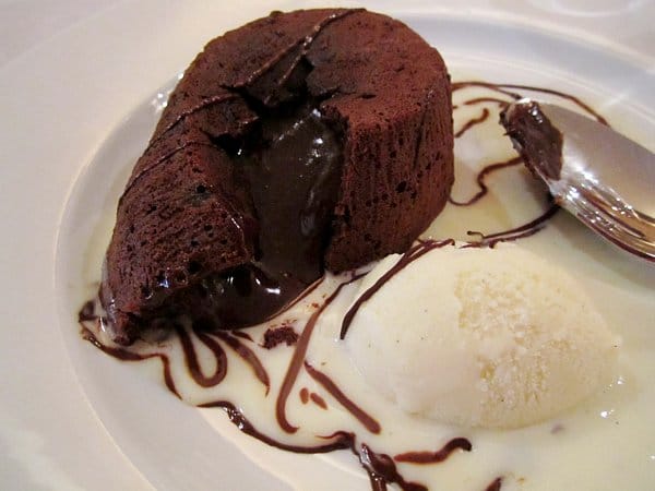 a chocolate lava cake on a white plate with chocolate oozing out of the center