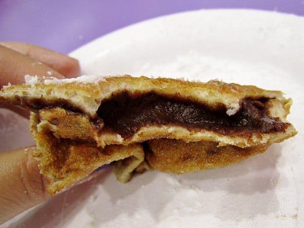 a half eaten doughnut filled with chocolate cream