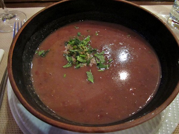 overhead view of a bowl of soup garnished with chopped herbs