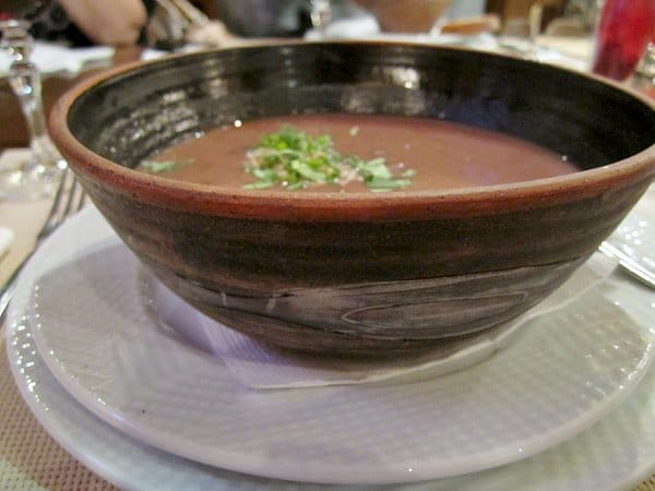 A bowl of soup garnished with chopped herbs