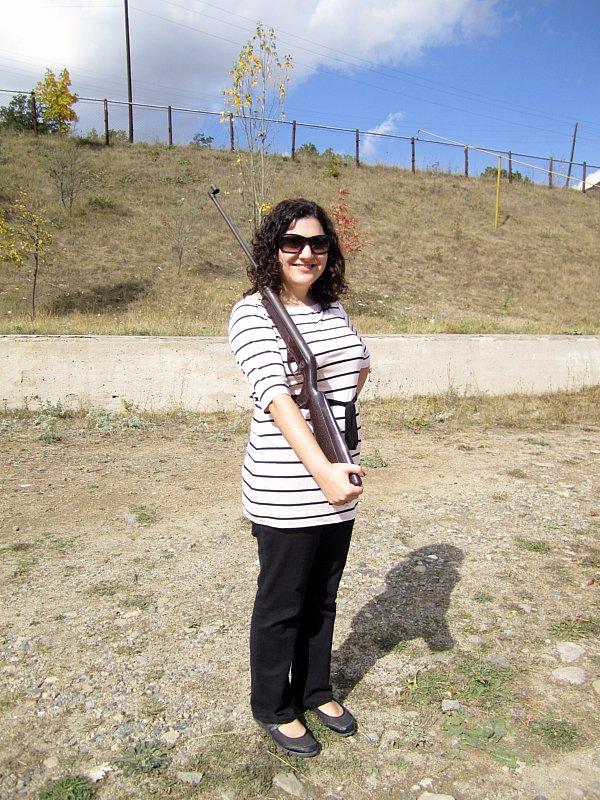 A woman with a bebe gun propped on her shoulder