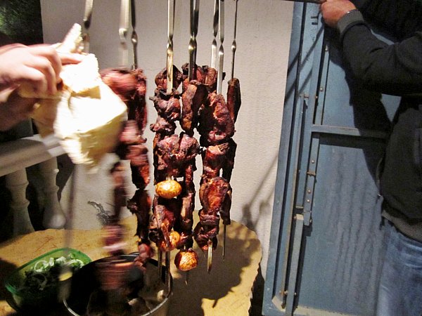 skewers of meat hanging vertically