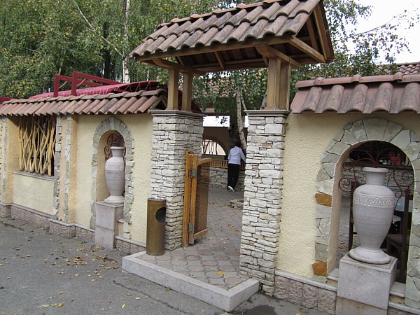 a stone lined entrance with large jugs on display on either side