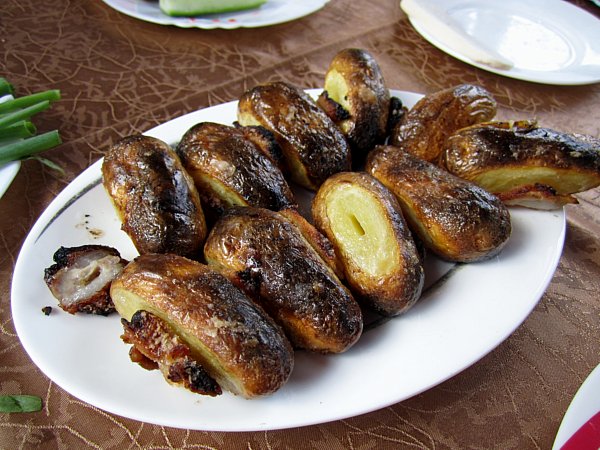 small oval grilled potatoes on a white platter