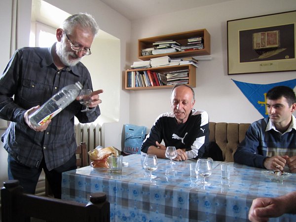 A group of people sitting at a table topped with small glasses