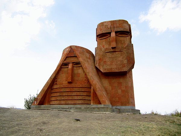 a red stone statue resembling a man and woman