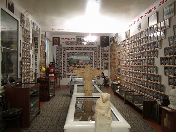 A room in a museum lined with framed photos of people on the walls