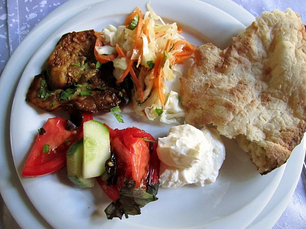 A plate of food with bread, vegetables, and strained yogurt