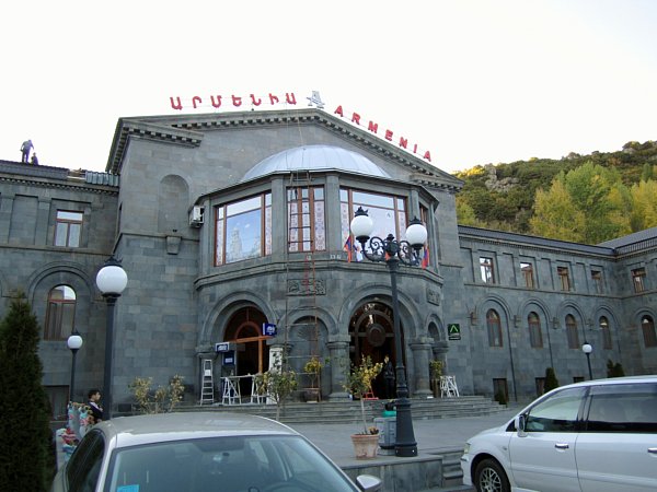 exterior of a stone building with cars parked in front