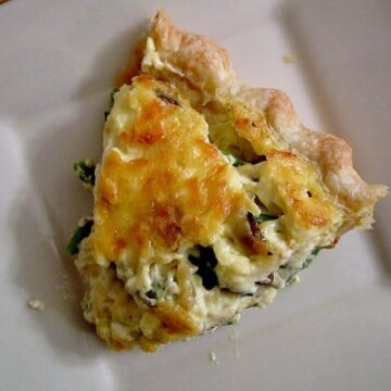 overhead view of a slice of quiche on a square white plate