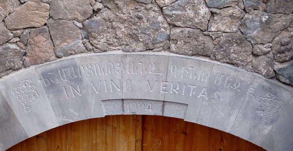 an engraved stone sign that says In Vino Veritas