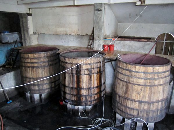 large wooden barrels being filled with wine