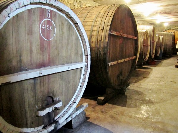 a closeup of wine barrels lining a wall